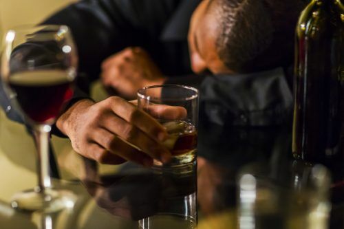 Drunk man passed out on a table at a pub