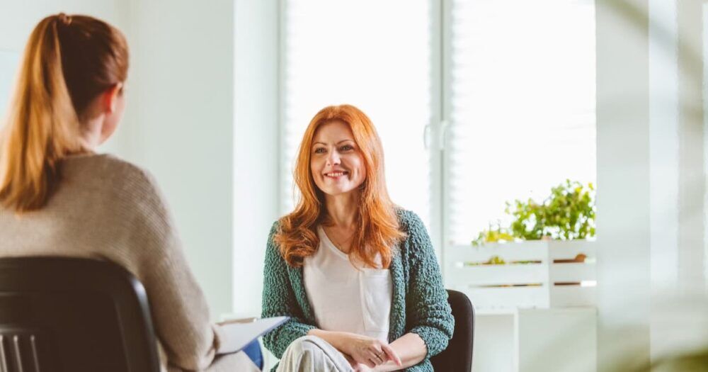 Therapy session between two women at alcohol rehab in Edmonton