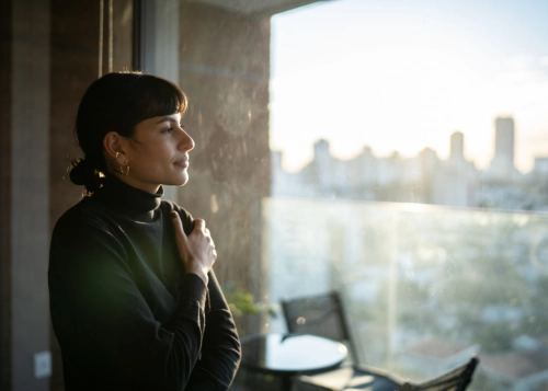gratitude and recovery. A woman looking at peace looking out of a window.