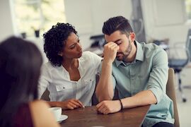 Picture of man receiving support from care professional at a drug rehab treatment facility