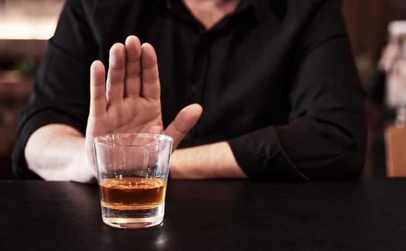 A man refusing a drink in a bar