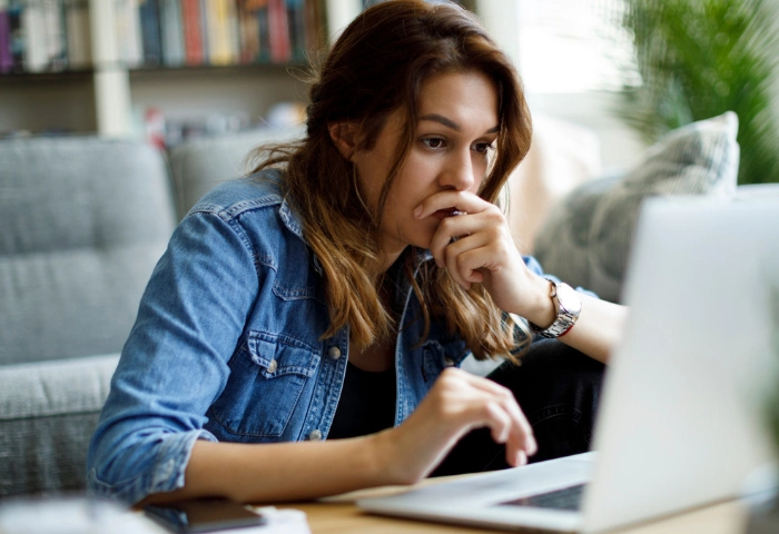 Can you be addicted to stress? An image of a young woman looking worried whilst working at home.