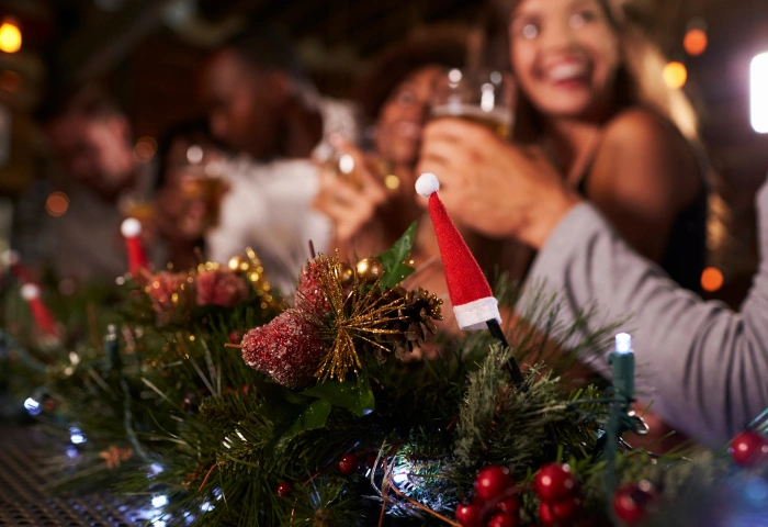 How to Cut Down on Alcohol Over Christmas. An image of a Christmas party at a bar, with the camera focus on foreground decorations