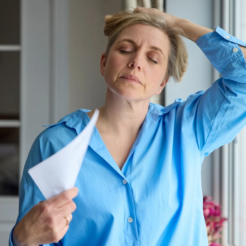 A woman sweating, cooling herself down